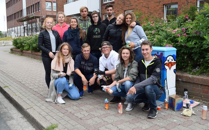 Schüler des Schulzentrums Sylt vor einem verschönerten Verteilerkasten