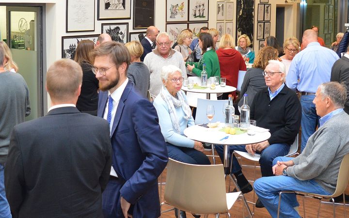Menschen sitzen bei Getränken und Essen zusammen und unterhalten sich