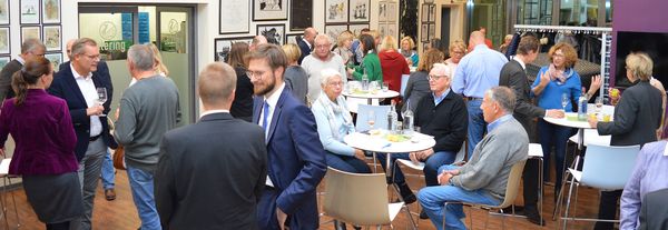 Menschen sitzen bei Getränken und Essen zusammen und unterhalten sich