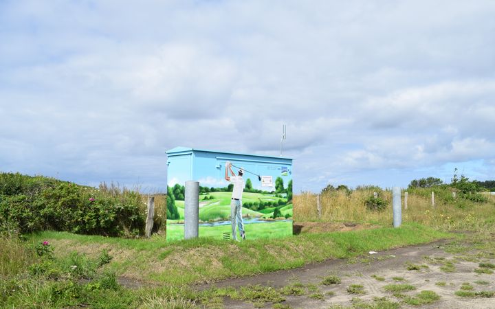 Eine Trafostation bemalt mit einem Golfer