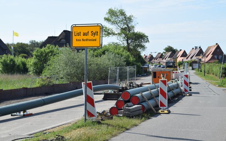 Baumaterialien liegen hinter dem Ortsschild von List